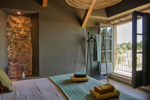 - une chambre avec un lit, des serviettes et une fenêtre dans l'établissement Sous le mûrier - Mas Provençal au coeur des vignes, à Travaillan