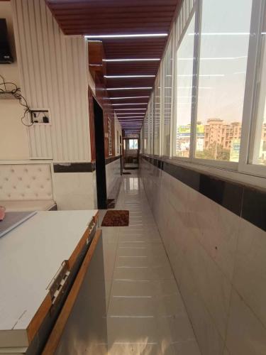 an empty hallway in a building with a large window at Hotel O Good Day Guest House in Alandi