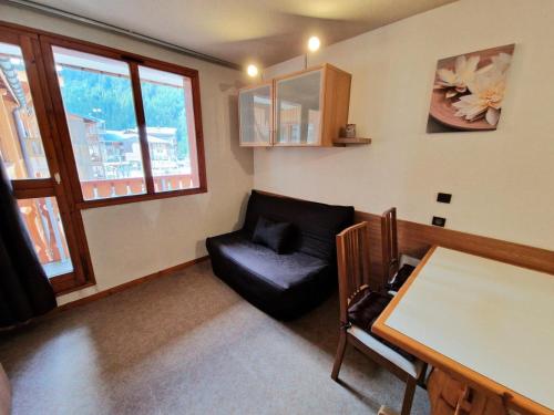 un salon avec une chaise en cuir noir et une table dans l'établissement Résidence Melezets 1 - Studio pour 5 Personnes 46, à Modane