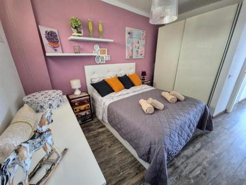 a bedroom with a bed with two stuffed animals on it at Arenas Negras Apartament Malaga in Puerto de Santiago