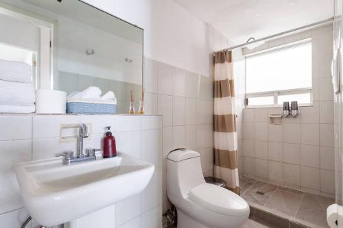 a white bathroom with a sink and a toilet at Distrito Spencer 2 BR apartment in Polanco in Mexico City