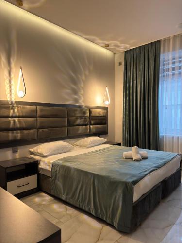 a bedroom with a large bed with two towels on it at New Milan Mountain Ponoramic Hotel, with indoor heated swimming pool in Gabala