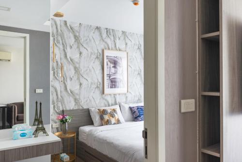 a bedroom with a bed and a marble wall at Dazzle Sukhumvit 7 by LeFoyer in Bangkok