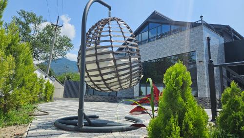 a sculpture of a egg on a pole in a yard at New Milan Mountain Ponoramic Hotel, with indoor heated swimming pool in Gabala