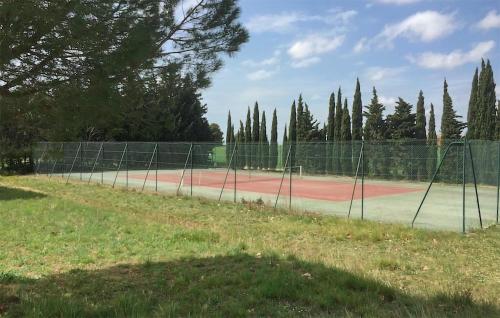 un court de tennis entouré d'une clôture dans l'établissement Nice Home In Cesseras With Wifi, à Cesseras
