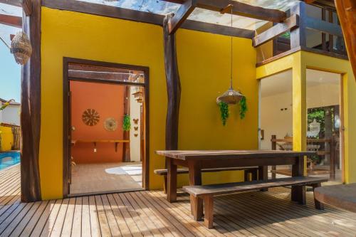 a patio with a bench and a yellow wall at Nova Pousada Don Pepe in Barra Grande