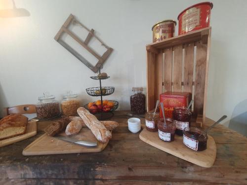 una mesa de madera con pan y otros alimentos. en Le Fin Chapon, en Excideuil