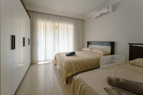 a bedroom with two beds and a window at Excelente Casa Parque do Ingá - JA217 in Maringá