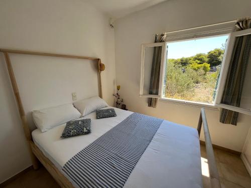 a bedroom with a bed with two pillows on it at Traditioneel Grieks zomerhuis dichtbij de zee in Vaia