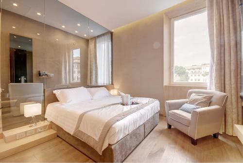 a bedroom with a bed and a chair and a window at Sun Suite Luxury Pantheon in Rome