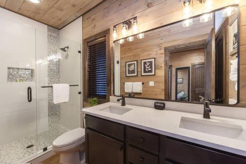 a bathroom with a sink and a toilet and a mirror at New! Mountain Luxe Heated Pool Arcade Spa Theater in Park Settlement