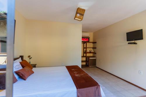 a bedroom with a bed and a tv on the wall at Nova Pousada Don Pepe in Barra Grande