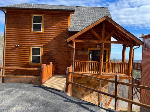 a log cabin with a porch and a deck at Fuzzy's Den in Pigeon Forge