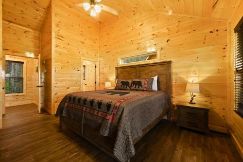 a bedroom with a bed in a log cabin at Fuzzy's Den in Pigeon Forge