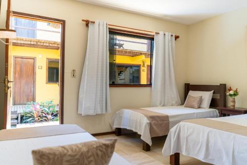 a bedroom with two beds and a window at Nova Pousada Don Pepe in Barra Grande