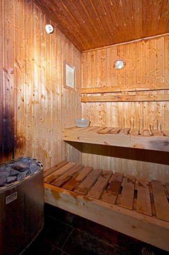 a wooden bathroom with a bench and a trash can at Pool-bikes-escooter! 2bed central in Auckland