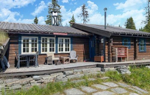 a log cabin with a porch and a table and chairs at Awesome Home In Aurdal With Sauna in Aurdal