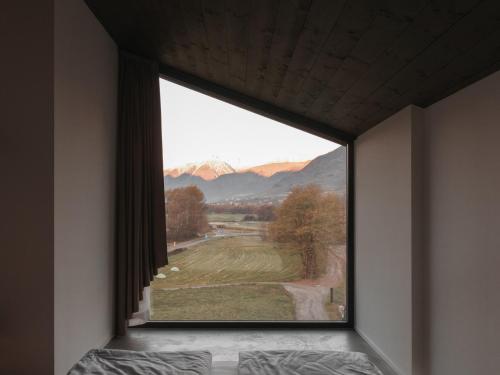 a window in a bedroom with a view of a mountain at Agriturismo B&B Caffè e Vino in Sondrio