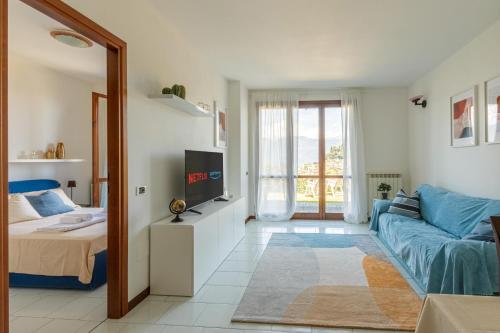 a living room with a blue couch and a tv at "Panorama sul Lago" Lake Maggiore, Free Wifi Netflix and Tennis in Brezzo
