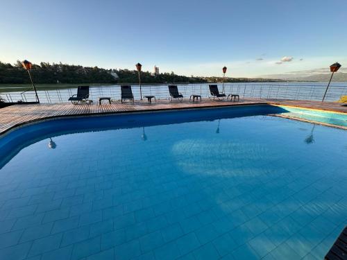 a large swimming pool with chairs and the water at Ciervo de Oro in Villa Carlos Paz