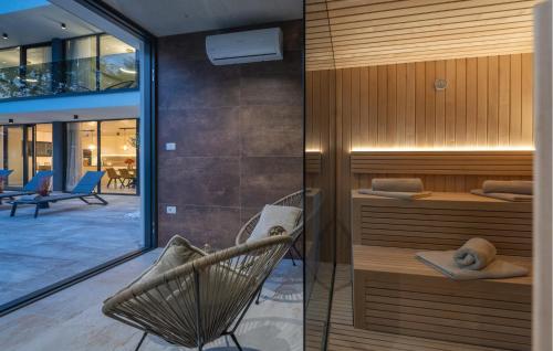 a room with a chair and a glass wall at Amazing Home In Modrusani With Sauna in Modrušani