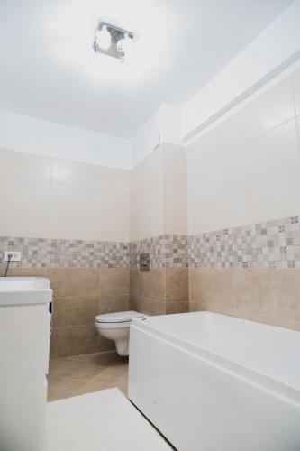 a bathroom with a white tub and a toilet at Deluxe in Valea Lupului
