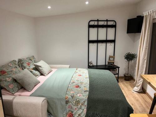 une chambre avec un lit avec une couverture dessus dans l'établissement Studio Les Chênes Verts proche Gorges de l'Ardèche, à Labastide-de-Virac