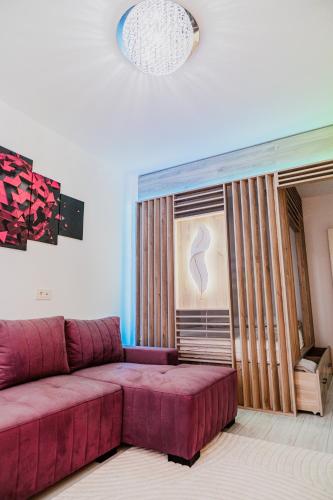 a living room with a purple couch and a window at Deluxe in Valea Lupului