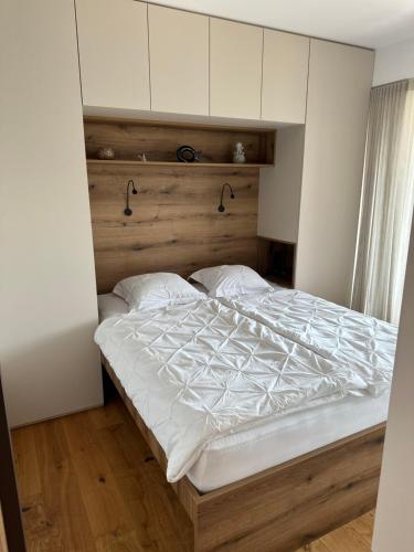 a bedroom with a bed with a wooden headboard at Apartment Deluxe Ossiacher See - Gerlitzen in Sattendorf