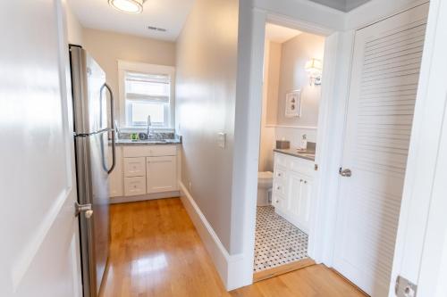 a kitchen with white cabinets and a refrigerator at The Newport Lofts - 194 Thames Street in Newport