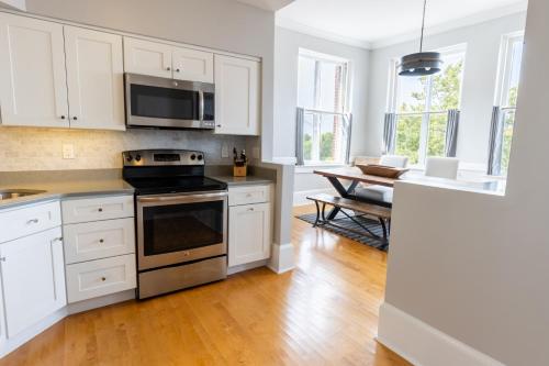 a kitchen with white cabinets and a stove top oven at The Newport Lofts - 194 Thames Street in Newport