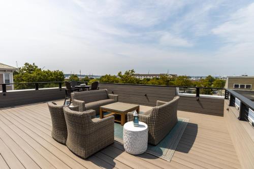 a deck with chairs and a table on a roof at The Newport Lofts - 194 Thames Street in Newport
