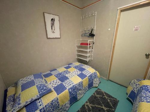 a bedroom with a bed with a blue and yellow quilt at B&B Patagonia Dreams in Puerto Montt