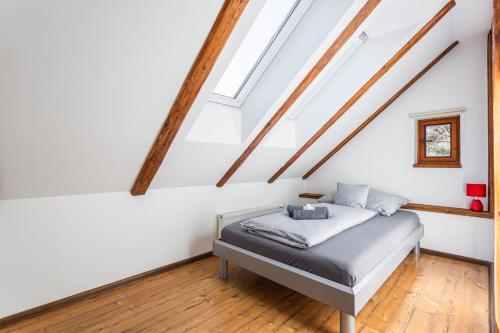 a bed in a room with white walls and wooden beams at Elements Apartments & Renata in Božičany