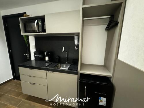 a small kitchen with a sink and a refrigerator at Move - Tambaú in Tambaú