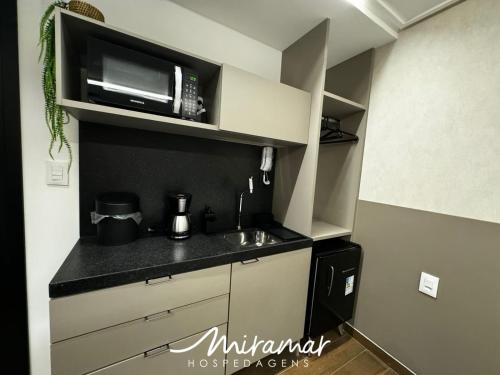 a kitchen with a counter top with a microwave at Move - Tambaú in Tambaú