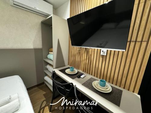 a room with a tv and a table with two hats at Move - Tambaú in Tambaú