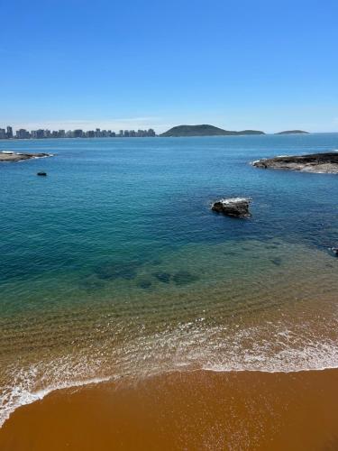a large body of water with a sandy beach at Casa do Mar in Guarapari