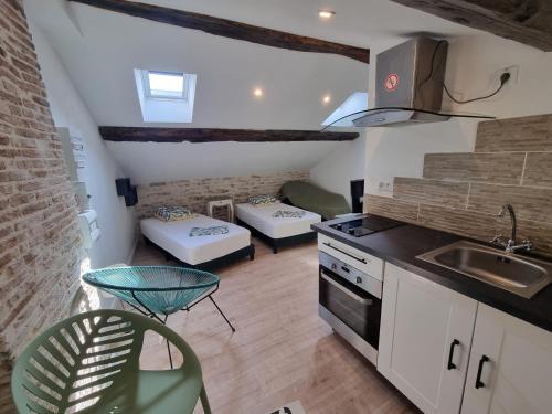 une cuisine avec un évier et une cuisinière four supérieur dans l'établissement Le Studio du Docteur Privey - Free & secure Park Bike -3mn Autoroute, à Tournus