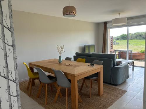 un salon avec une table et des chaises en bois dans l'établissement Appartement spacieux et clair proche des plages de la baie, à Quiberon