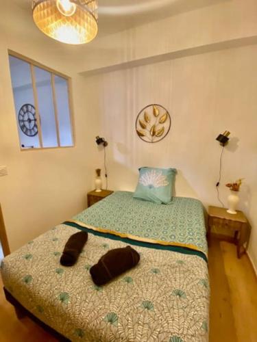 une chambre avec un lit avec deux pantoufles dessus dans l'établissement Le standing du centre historique, à Périgueux