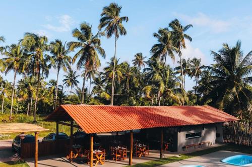 a resort with palm trees in the background at Pousada Pé na Areia in São Miguel dos Milagres