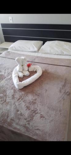 a bed with two stuffed animals in a ring on it at Pousada Ilha do Sol in Salinópolis