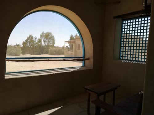an arched window in a room with a table at Talist Siwa in Siwa