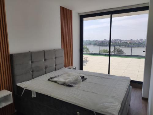 a bed in a room with a large window at Kaskade Hill Apartments in Novi Sad