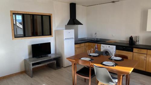 a kitchen with a table with chairs and a microwave at Appartement spacieux in Frasne
