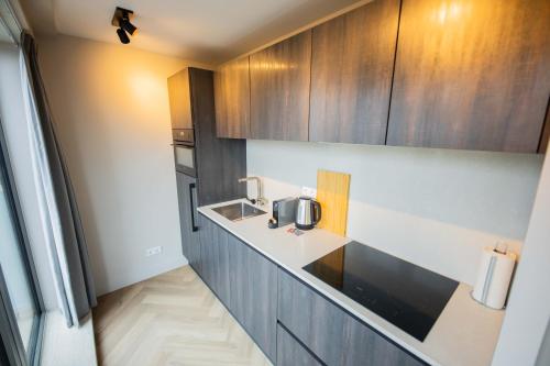 a kitchen with wooden cabinets and a sink at Kerkstraat in Hilversum