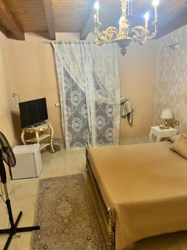 a bedroom with a bed and a television and a chandelier at B & B Temptation Airport Fontanarossa shared house with several rooms in Catania