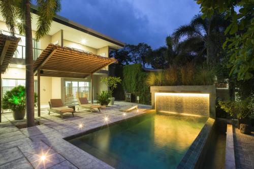 a swimming pool in the backyard of a house at Tamarindo Bay Boutique Hotel, Apartments & Suites in Tamarindo