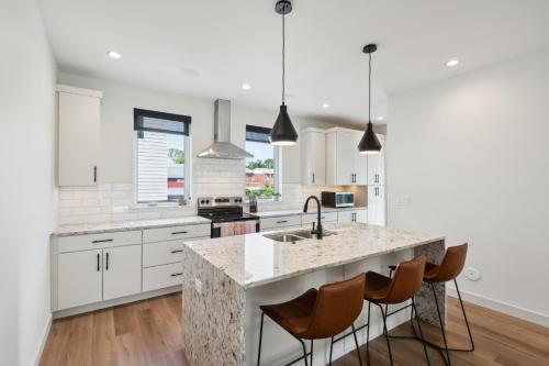 a kitchen with white cabinets and a marble counter top at New Modern Townhome with Rooftop Patio townhouse in Iowa City